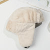 A beige classic Russian ushanka trapper hat with thick light-colored fur lining displayed on a white surface.