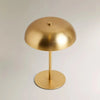 A round, brass-colored portable touch table lamp with a central stand and base.