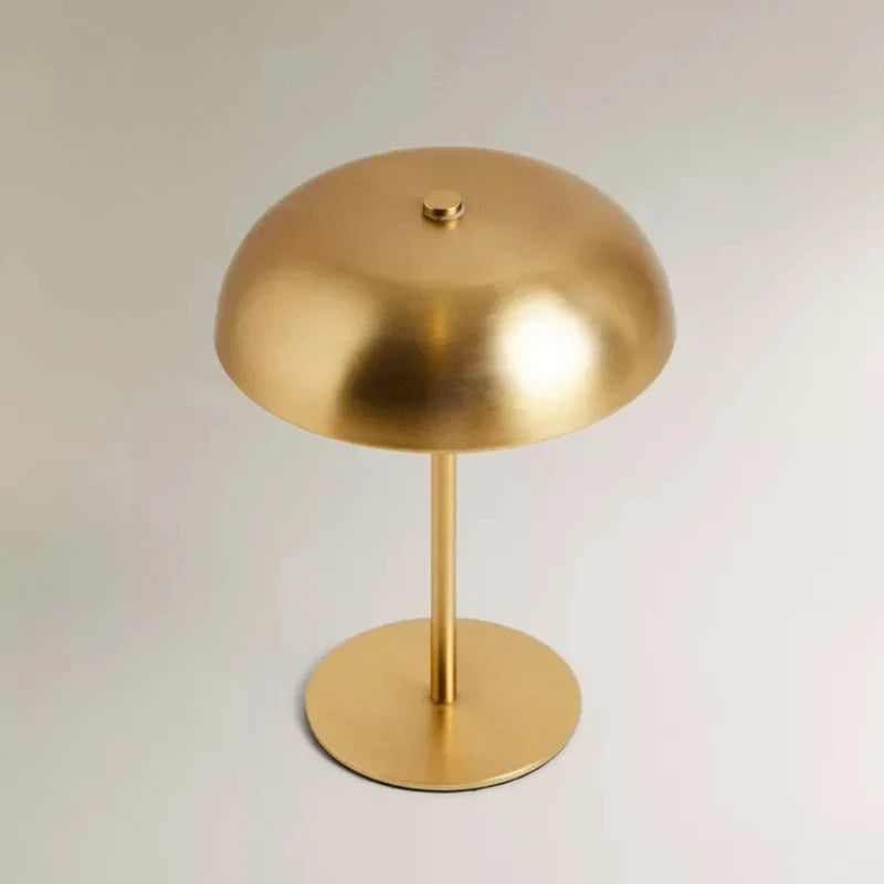 A round, brass-colored portable touch table lamp with a central stand and base.
