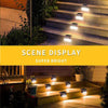 A set of solar powered deck lights illuminating outdoor steps and pathways at night.