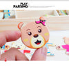 A hand holds a wooden puzzle shaped like a cute bear for children's dress-up play.