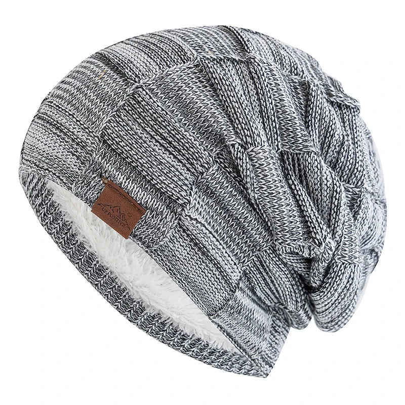 A gray and white knit slouchy beanie with a textured pattern and a white sherpa lining.