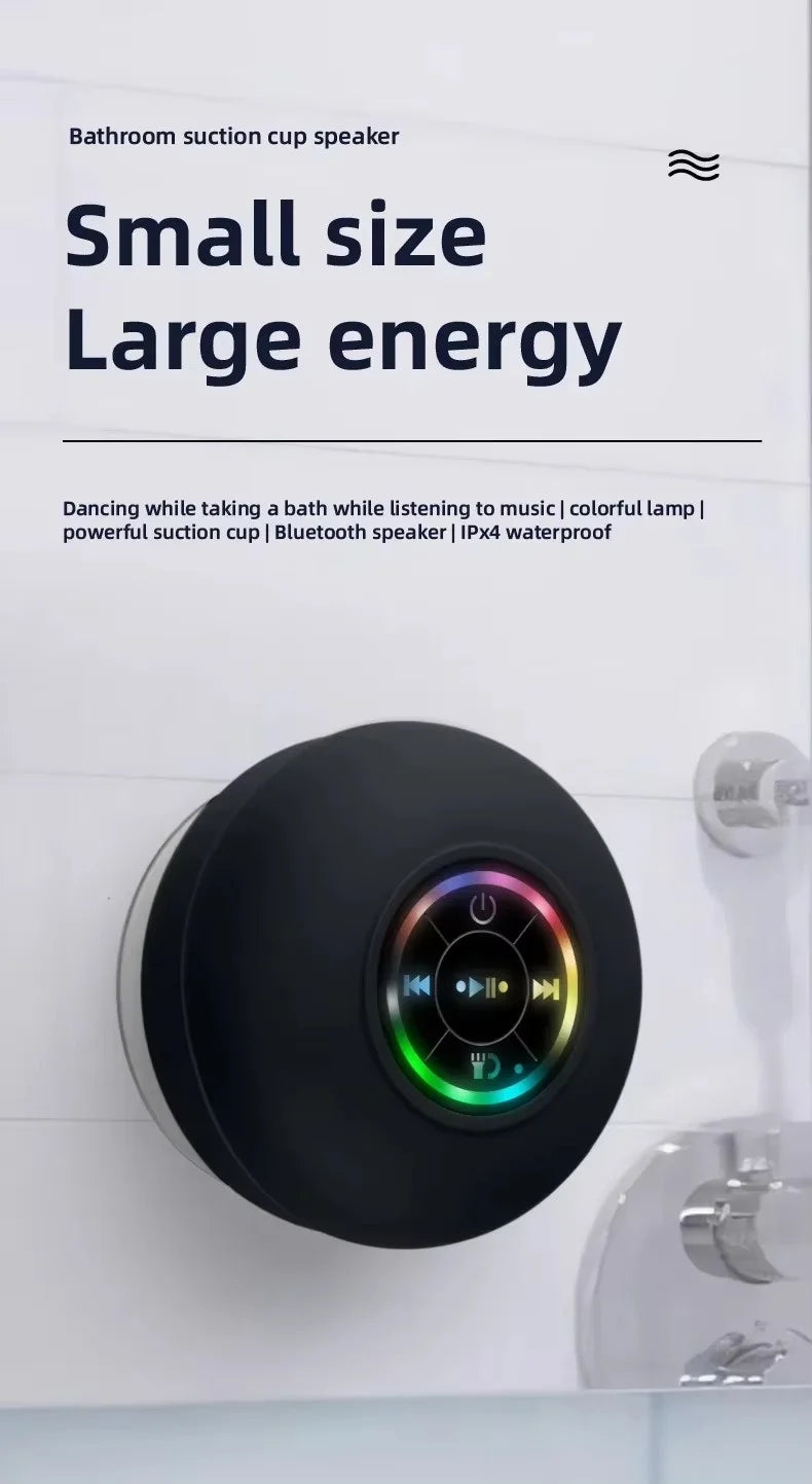 A black bathroom suction cup speaker is mounted on a white tile, with text describing its small size and large energy.