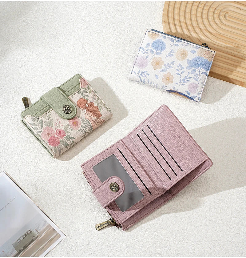 A pink floral print women's wallet with a zipper and card slots is shown next to a light blue floral print wallet.