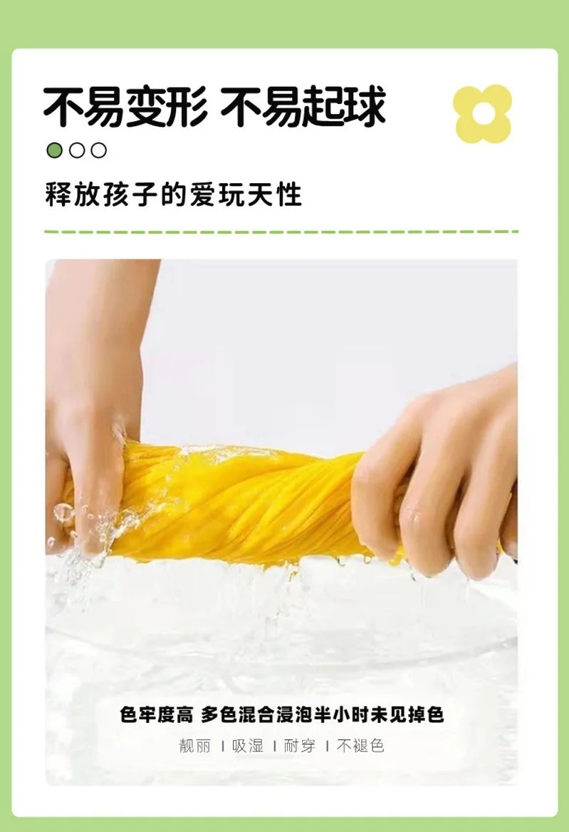 A hand is squeezing bright yellow liquid, likely a paint or dye, into a white surface.