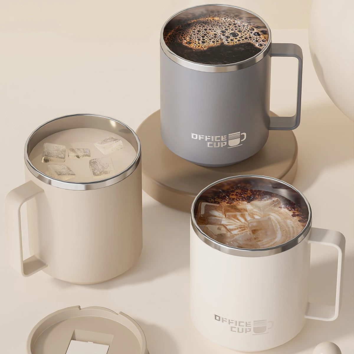 A set of two beige double wall insulated stainless steel travel mugs, one filled with coffee and the other empty.