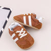 A pair of brown and white striped baby first walker shoes with canvas upper and anti-slip sole