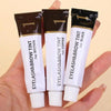 A hand holds a tube of Eyelash & Brow Tint, featuring brown tint and black tint options.