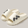 A pair of beige EVA slide slippers with a black wavy design shown from above.