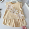 A light beige girls' summer floral t-shirt and shorts set featuring delicate white flower embroidery.