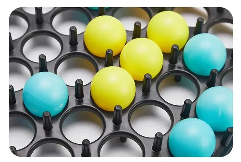 A collection of bright yellow and blue plastic bounce balls arranged in a black grid for a tabletop game.