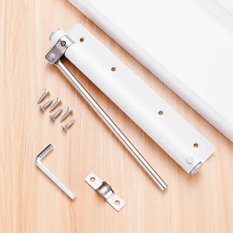 Stainless steel automatic door closer with an invisible spring mechanism and mounting hardware on a wooden surface.