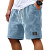 Pantalones cortos casuales de hombre con textura waffle y cordón, en tejido gris azulado, usados por una persona.