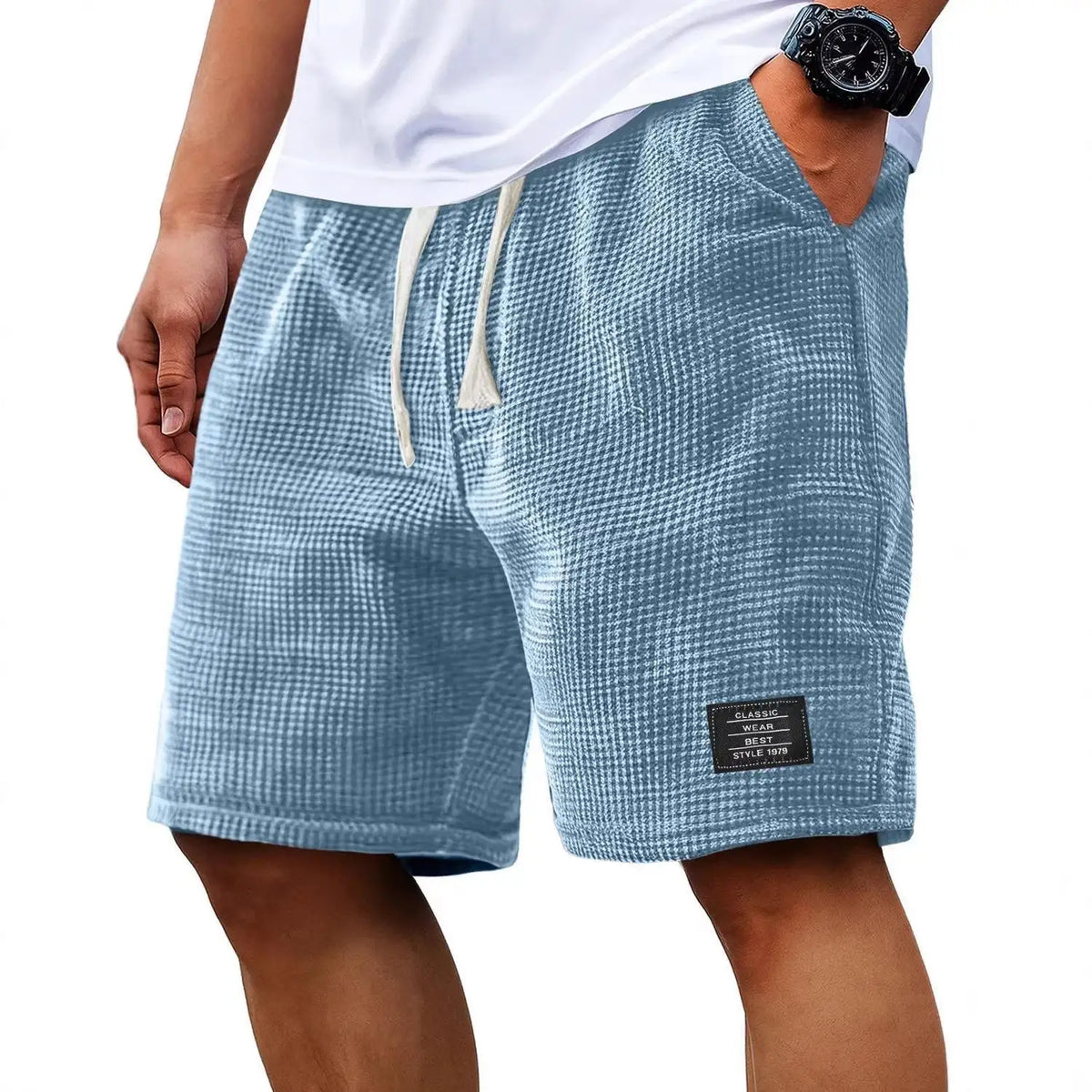 Pantalones cortos casuales de hombre con textura waffle y cordón, en tejido gris azulado, usados por una persona.