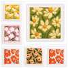 Fire firkantede broderiprøver med blomstermotiver i gult, pink og orange på hvid baggrund.