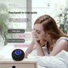 A woman is using a compact waterproof Bluetooth speaker with a silicone plug to chat easily in a bathroom setting.