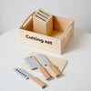 A wooden cutting set with a block-shaped knife and a larger blade is displayed in a wooden box.