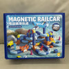 A box for a magnetic railcar toy set featuring various colored vehicles and tracks.