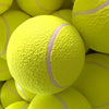 A close-up view of many bright yellow inflatable tennis balls piled together.