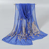 A royal blue gold shimmer chiffon scarf and head wrap draped on a hanger.