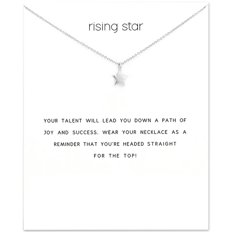 Collar con colgante de estrella plateada y cadena sobre tarjeta blanca.