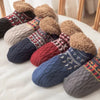 Collection de chaussettes en laine tricotée, couleurs et textures variées avec pompons duveteux.
