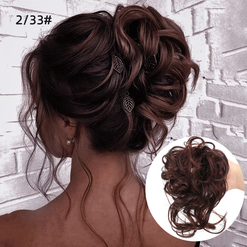 Primer plano de cabello castaño oscuro en un moño rizado despeinado con pequeños acentos de hojas.