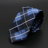 Corbata de cuadros azul oscuro y claro doblada sobre fondo oscuro.