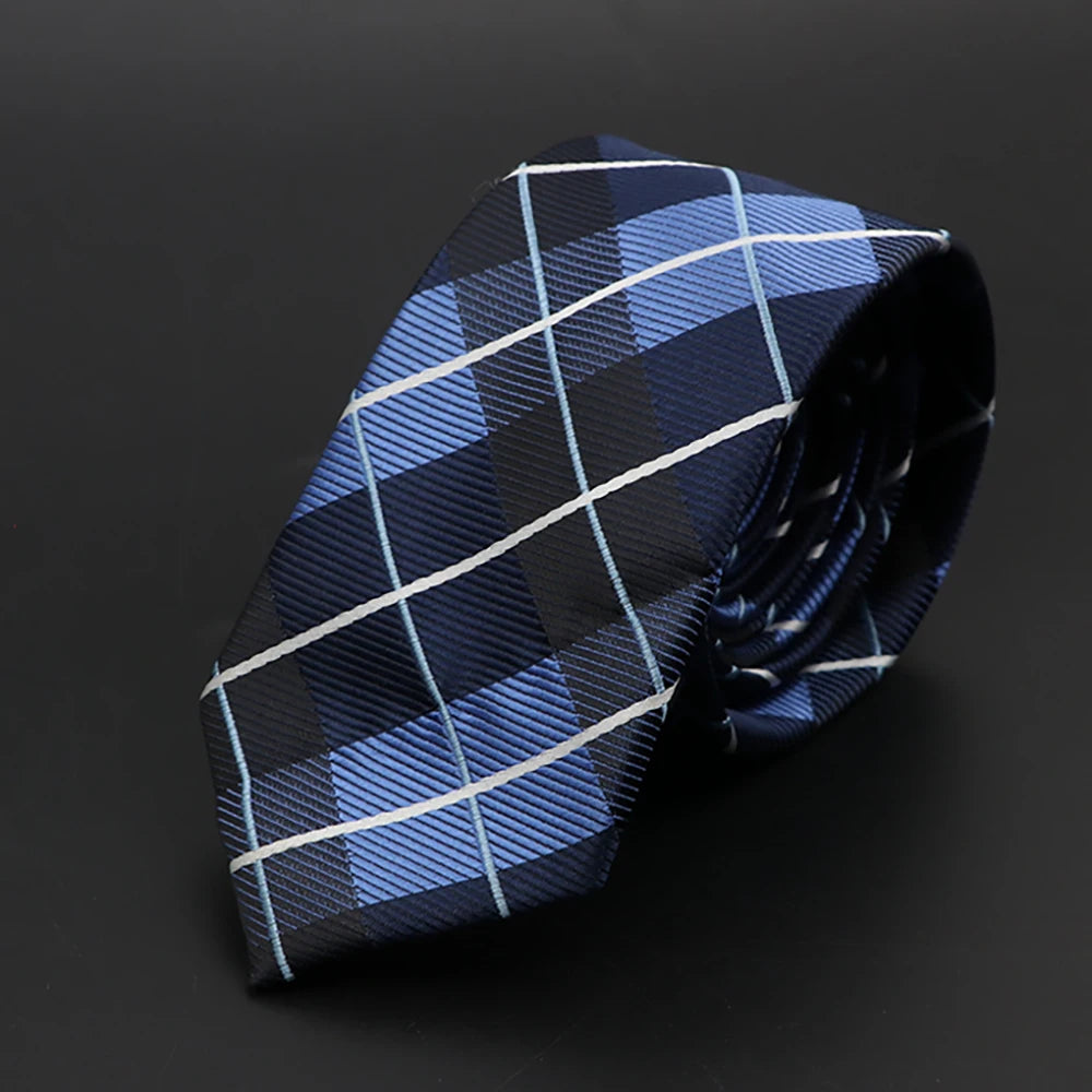 Corbata de cuadros azul oscuro y claro doblada sobre fondo oscuro.