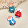 Three wooden Montessori busy board figures of animals dressed in clothing, including a bear, a elephant, and a fox.