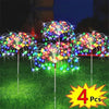 Four solar firework LED fairy lights shooting colorful sparks over a green lawn at night