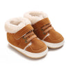 A pair of tan suede baby winter snow boots with fluffy cream-colored faux fur trim.