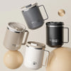 A collection of three double wall insulated stainless steel travel mugs in gray, beige, and white with lids and handles.