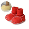 A pair of bright red suede leather winter booties with soft fur lining shown next to a fluffy yellow bootie.