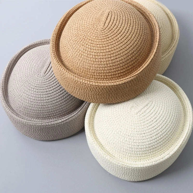 Three straw pillbox sun hats in beige, light gray, and cream colors shown from above.