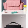 A pink Stroller Organizer Bag with a cup holder is shown next to a green silicone cup on a white surface.
