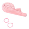 Pink heatless curling rod headband rolled into a spiral shape with pink hair ties nearby