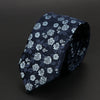 Corbata jacquard azul oscuro con diseños florales blancos, mostrada doblada.