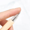 Una mano sostiene un bolígrafo de cuchillo de precisión transparente con una punta de cuchilla de repuesto.