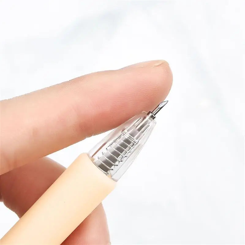 Una mano sostiene un bolígrafo de cuchillo de precisión transparente con una punta de cuchilla de repuesto.