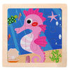 A wooden jigsaw puzzle featuring a pink, stylized dinosaur or sea creature in various shades of pink and purple against a blu