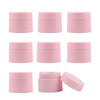 A set of pink refillable travel face cream jars with leak-proof lids shown in various angles.