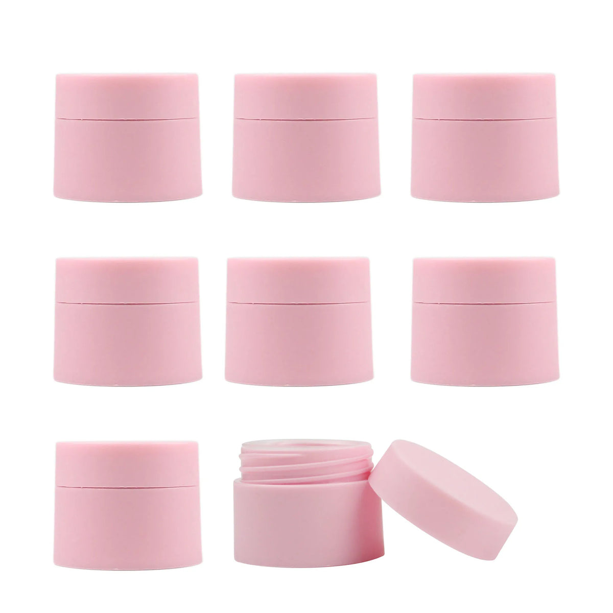 A set of pink refillable travel face cream jars with leak-proof lids shown in various angles.