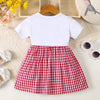A white long-sleeved cotton knit top paired with a red and white plaid pleated skirt for a girl's dress.