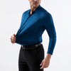 Un hombre con camisa de vestir azul oscuro de manga larga y pantalones negros.