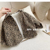 A leopard print denim jacket displayed on a hanger against a light background.