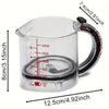 Clear plastic measuring cup with a black handle and scraper base, showing volume markings.