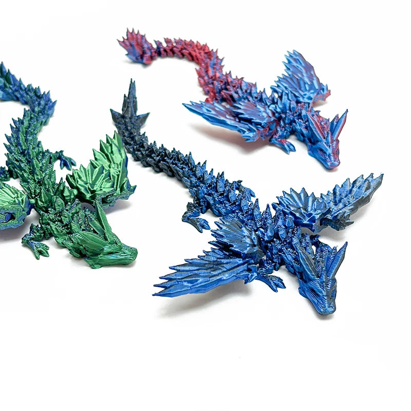 Tres figuritas de dragón articulado impresas en 3D, en verde, rojo y azul.