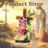 A wooden Jesus cross flower building set with pink and purple flowers displayed in a religious outdoor setting.
