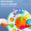 A hand is interacting with a silicone pull string sensory toy featuring textured bumps and colorful shapes for babies.